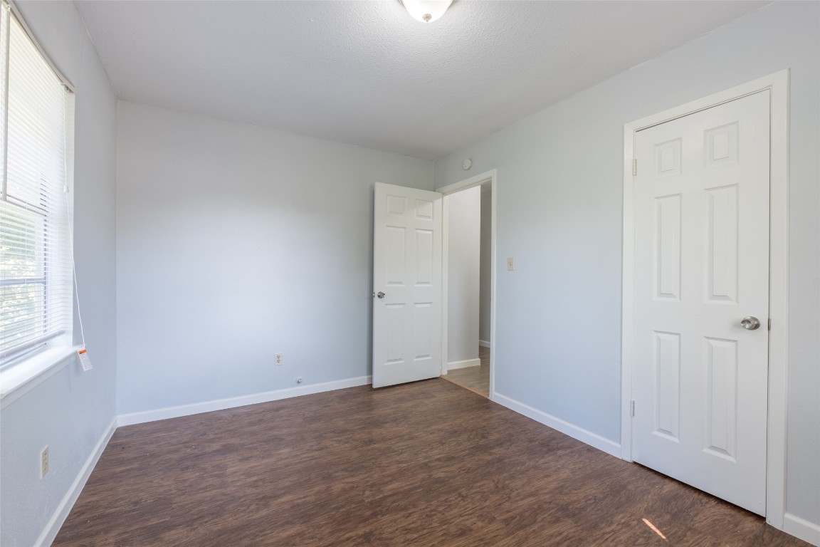 606 West Street Georgetown, TX 78626 - Photo 19 of 36 Unfurnished bedroom with dark wood finished floors and baseboards
