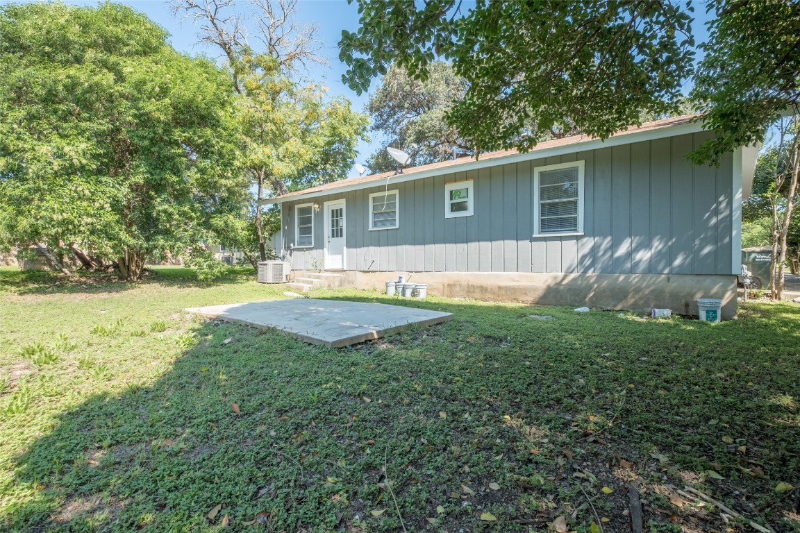 606 West Street Georgetown, TX 78626 - Photo 23 of 36 Back of house with a patio, a lawn, and board and batten siding
