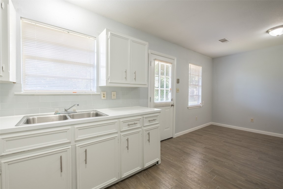 606 West Street Georgetown, TX 78626 - Photo 9 of 36 Kitchen with decorative backsplash, white cabinetry, light countertops, and dark wood-style flooring