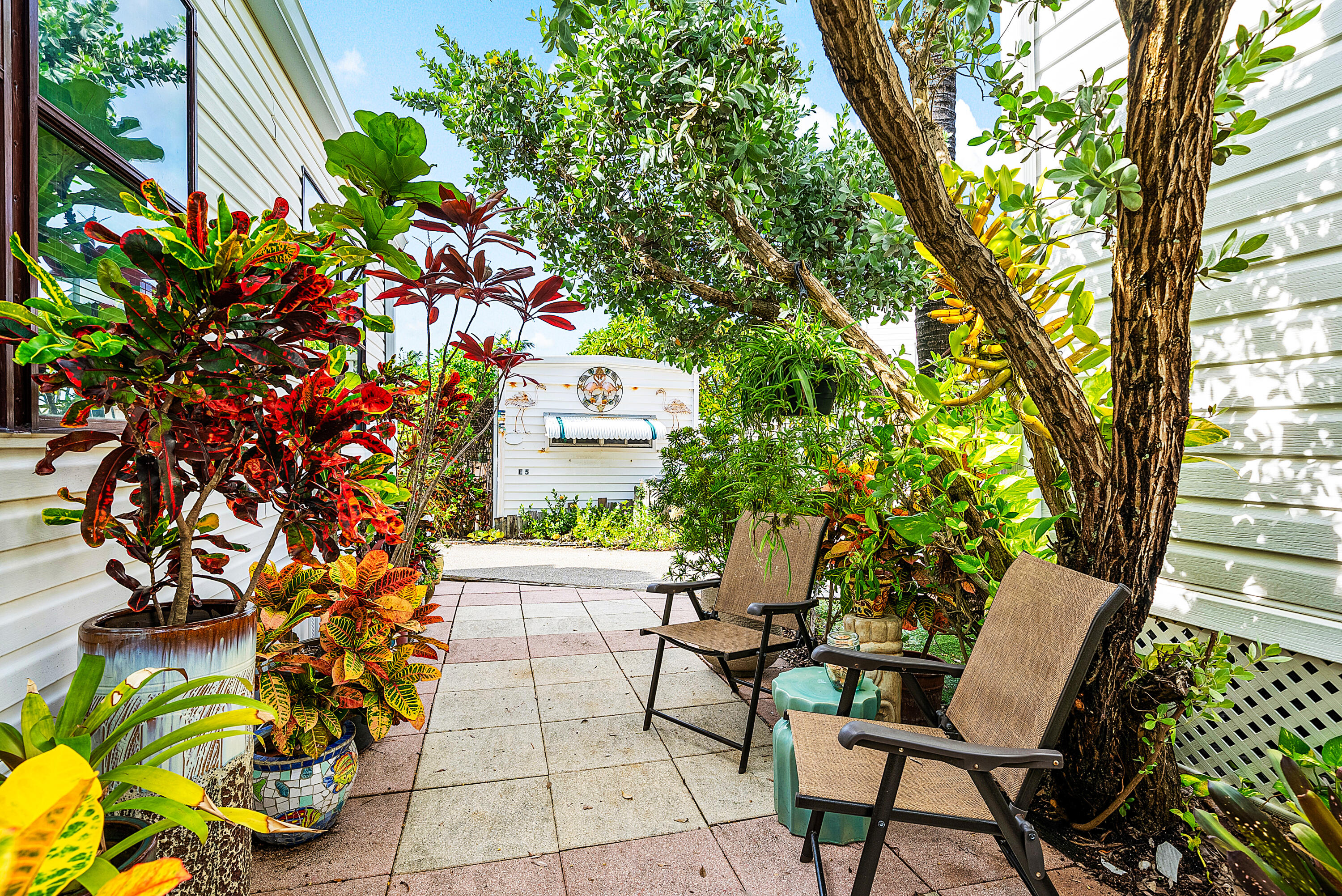 4 East Cedar Drive, Unit CD Briny Breezes, FL 33435 - Photo 23 of 28 a backyard of a house with lots of green space and garden