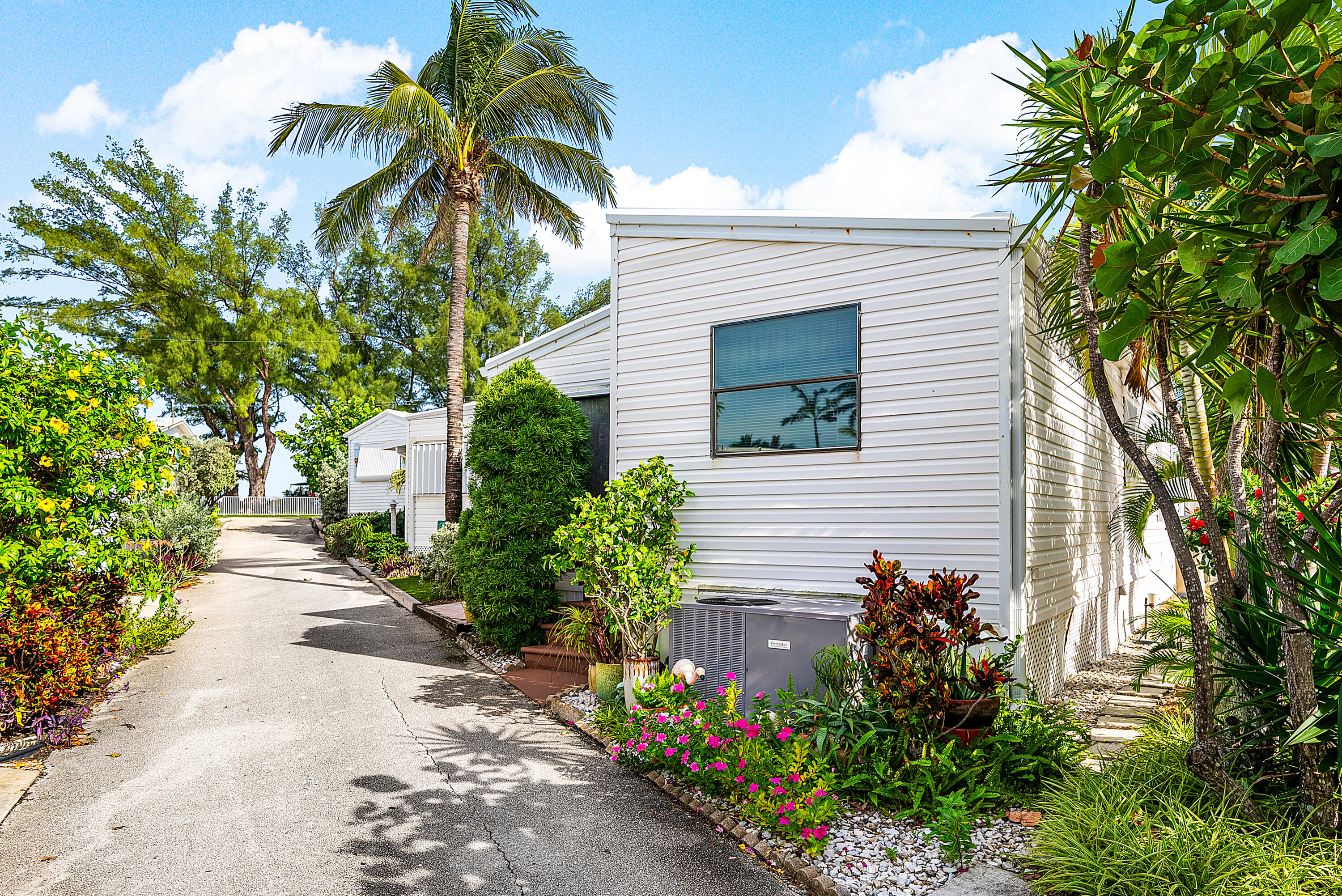 4 East Cedar Drive, Unit CD Briny Breezes, FL 33435 - Photo 27 of 28 a front view of a house with a yard and a garden