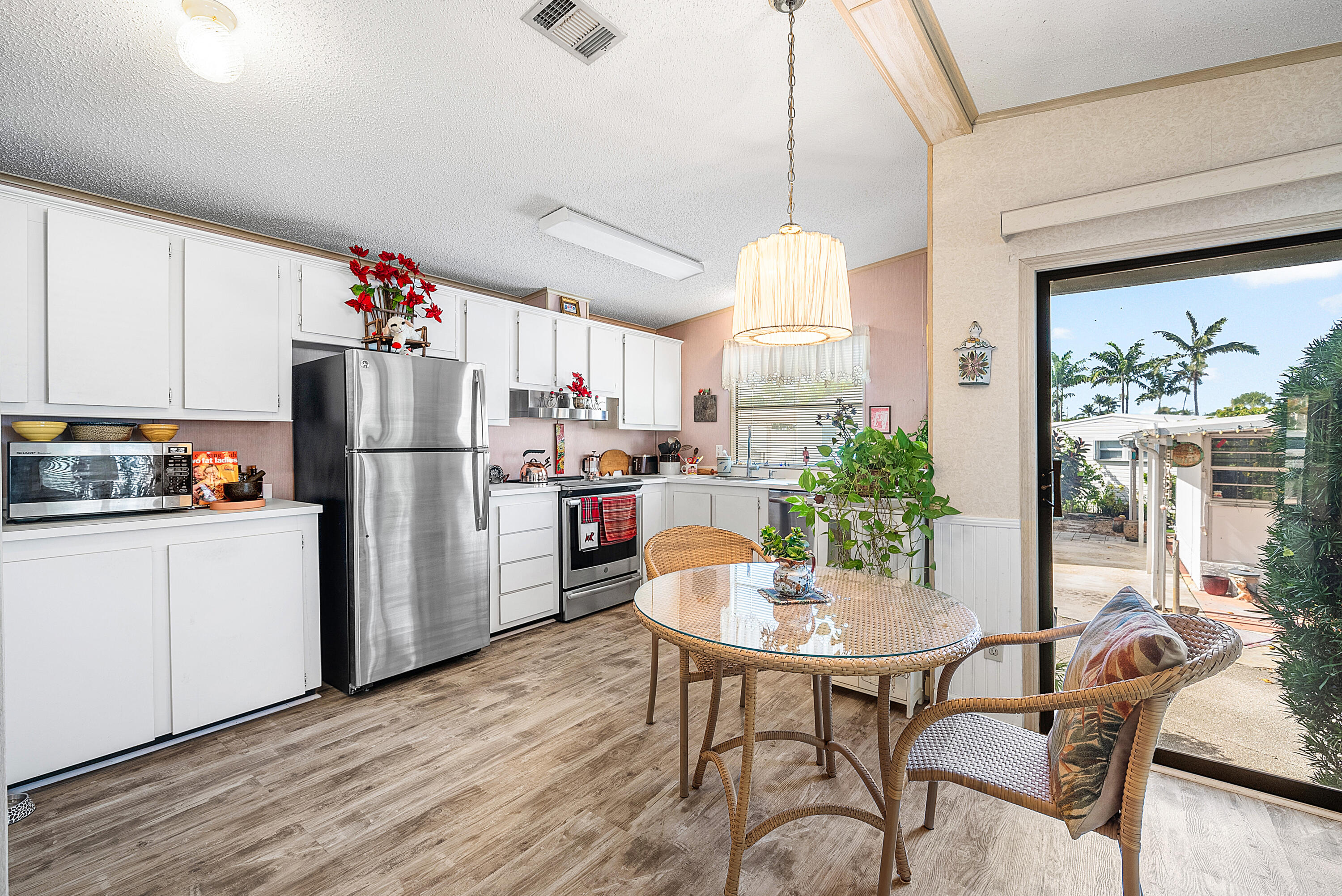 4 East Cedar Drive, Unit CD Briny Breezes, FL 33435 - Photo 8 of 28 a kitchen with stainless steel appliances a dining table chairs and chandelier