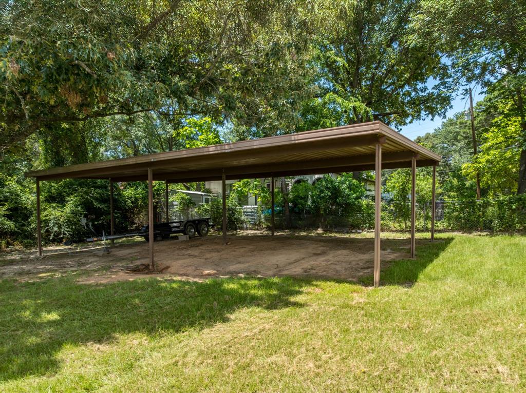 21516 Water Ridge Road Chandler, TX 75758 - Photo 26 of 40 a view of a backyard with table and chairs under an umbrella