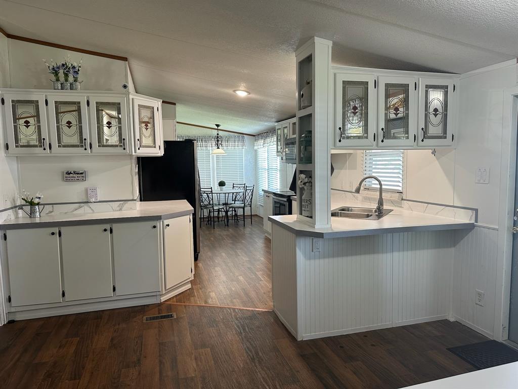 21516 Water Ridge Road Chandler, TX 75758 - Photo 6 of 40 a kitchen with a sink cabinets and wooden floor