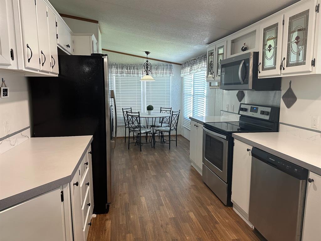 21516 Water Ridge Road Chandler, TX 75758 - Photo 7 of 40 a kitchen with granite countertop a refrigerator stove top oven and sink