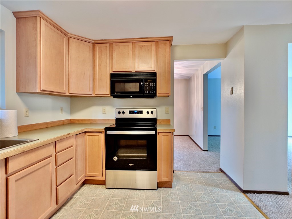 17819 Southeast 137th Street Renton, WA 98059 - Photo 11 of 37 a kitchen with stainless steel appliances granite countertop a stove microwave and sink