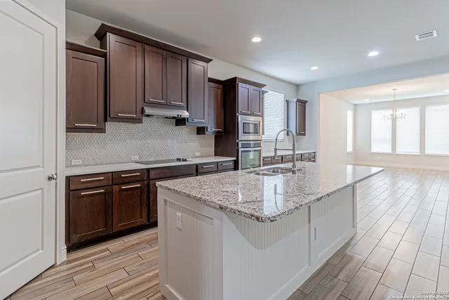 a kitchen with stainless steel appliances granite countertop a sink stove and cabinets