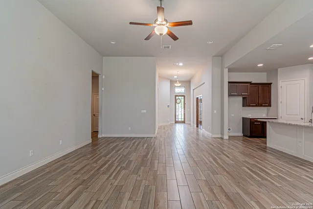 a view of a big room with wooden floor and a kitchen