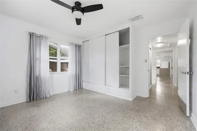 a view of empty room with wooden floor and window
