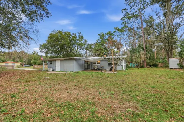 a backyard of a house with table and chairs