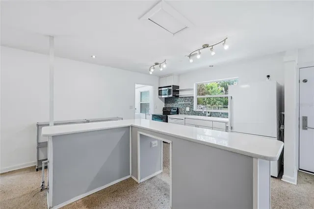 a kitchen with a sink a window stainless steel appliances and cabinets