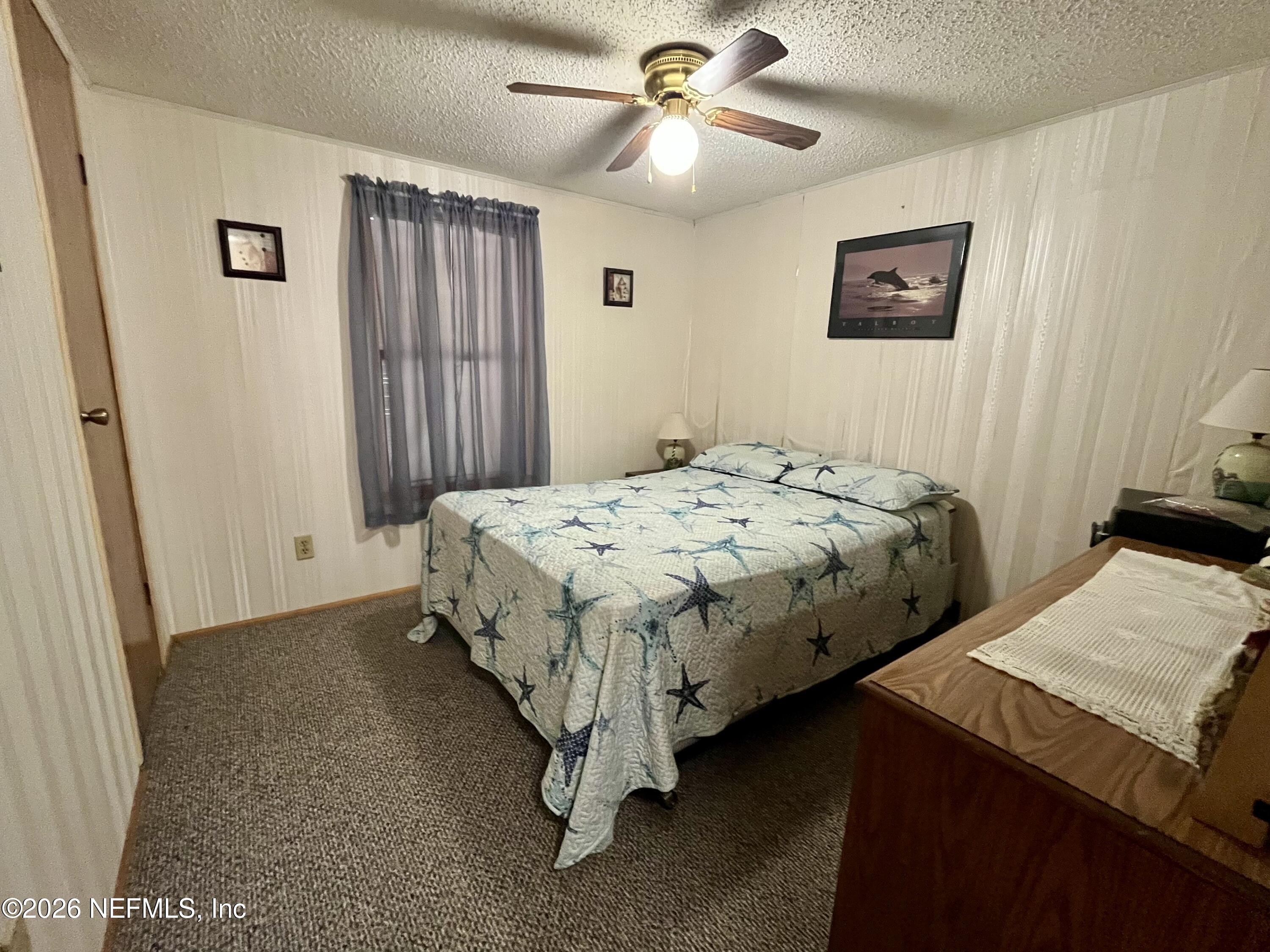 174 Buchanan Circle Satsuma, FL 32189 - Photo 13 of 16 a bedroom with a bed and a chandelier