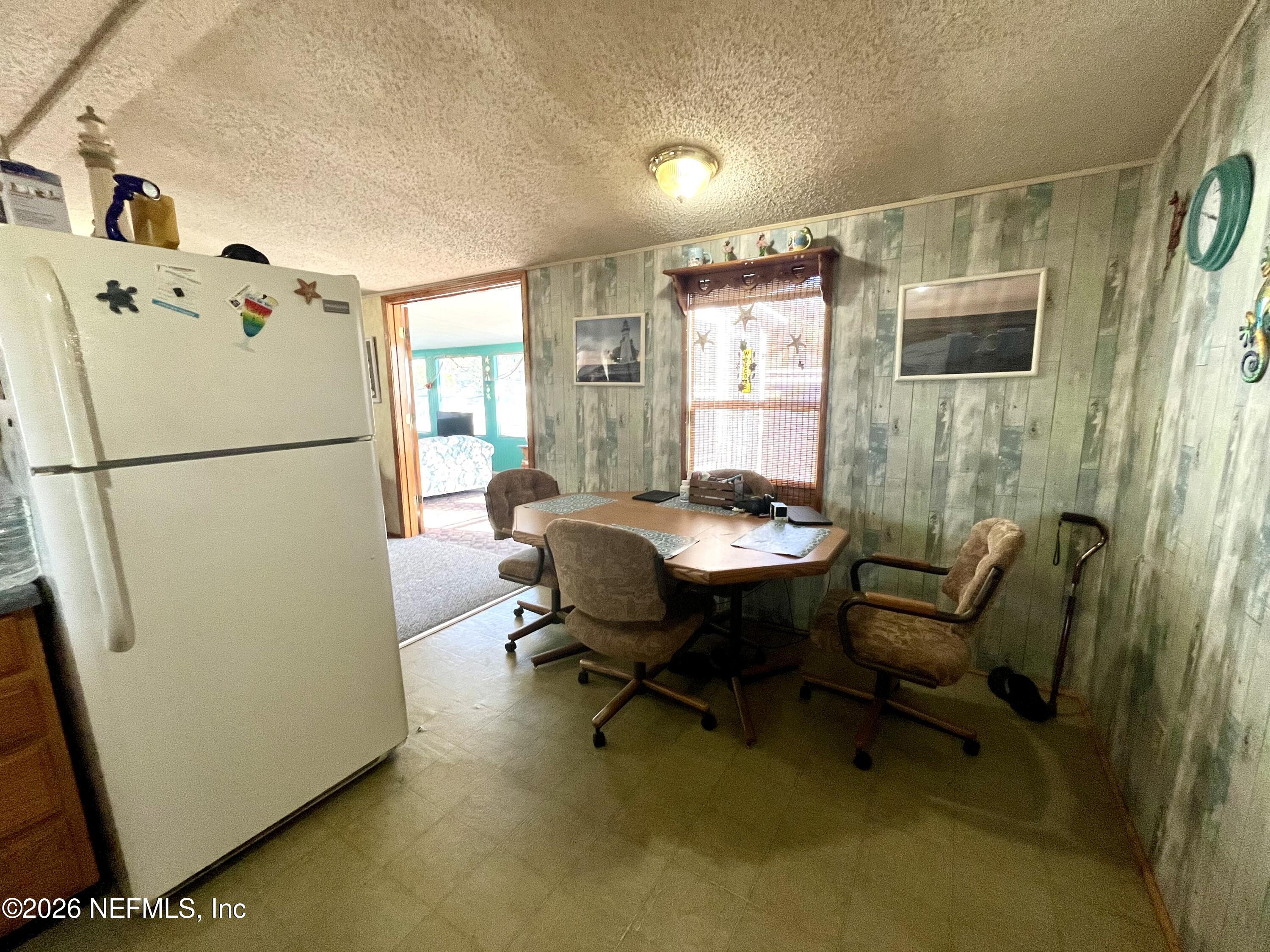 174 Buchanan Circle Satsuma, FL 32189 - Photo 15 of 16 a living room with chairs and a refrigerator