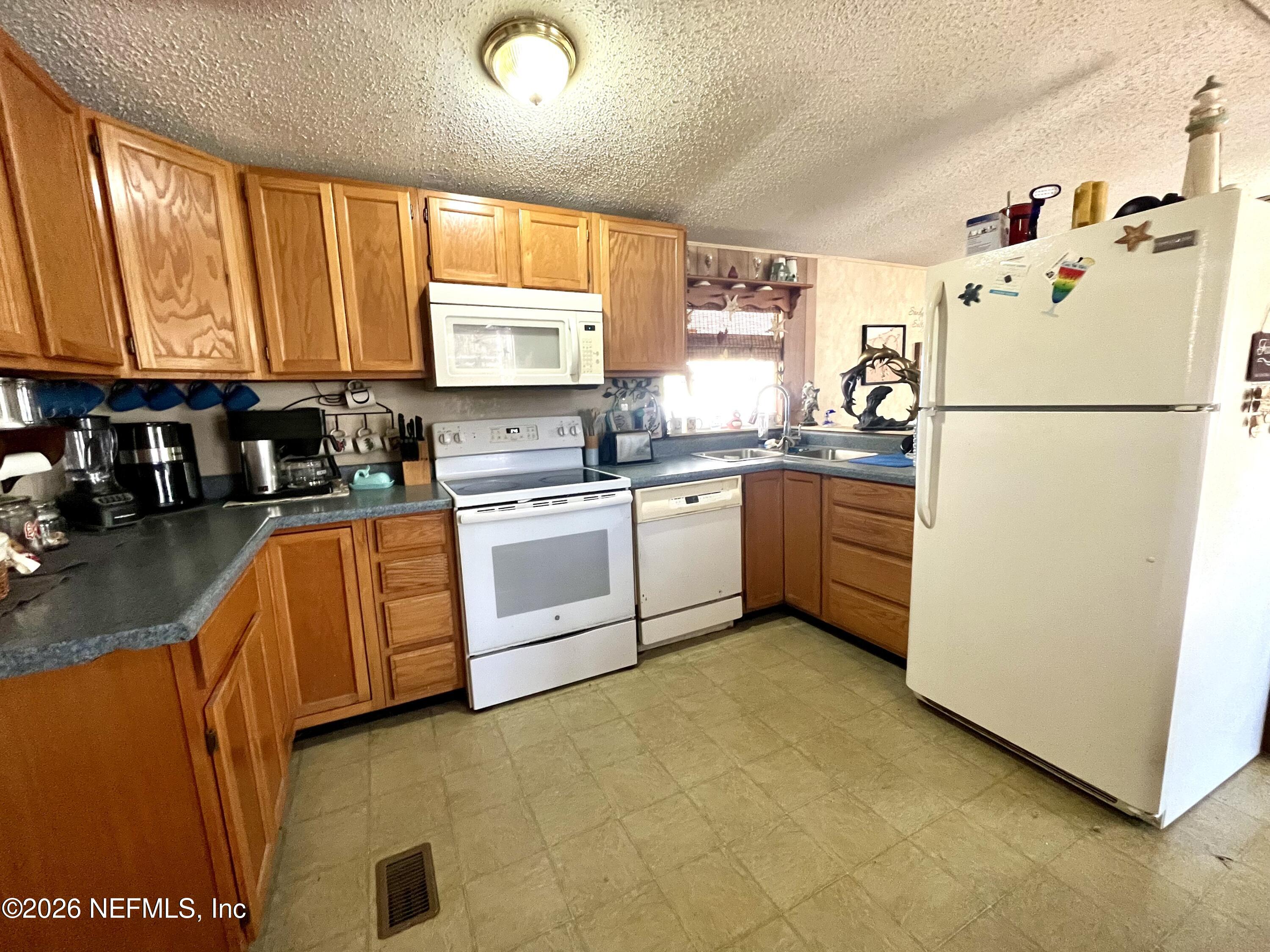 174 Buchanan Circle Satsuma, FL 32189 - Photo 7 of 16 a kitchen with cabinets a sink and white appliances