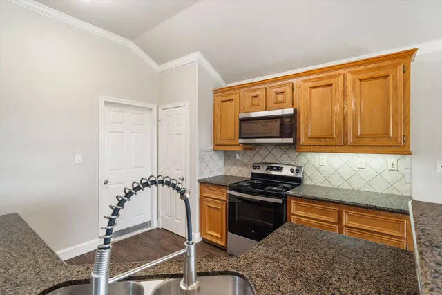 a kitchen with granite countertop a sink stainless steel appliances and cabinets