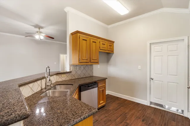 a kitchen with granite countertop cabinets sink and window