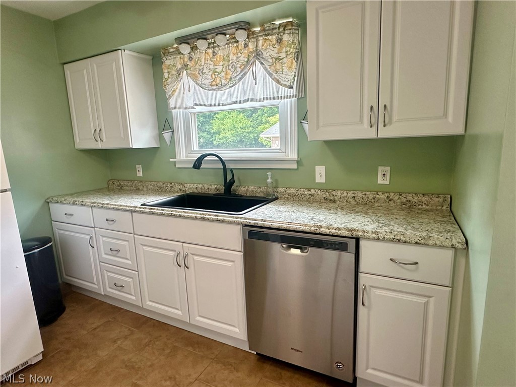 6855 Old Town Road Mount Perry, OH 43760 - Photo 8 of 38 Kitchen featuring white cabinets, light tile patterned floors, sink, and stainless steel dishwasher
