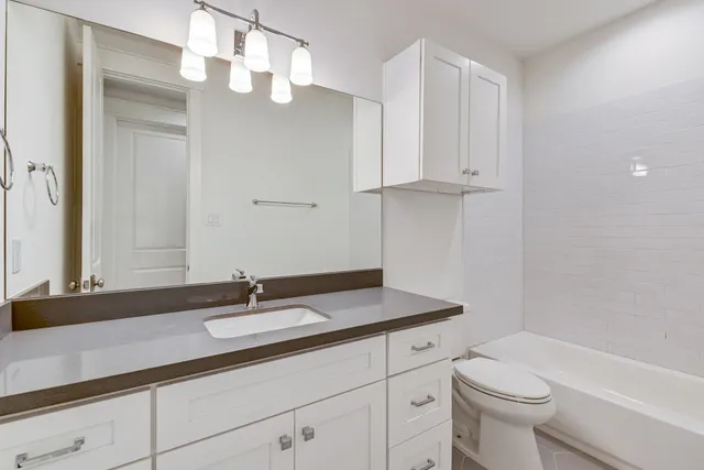 a bathroom with a sink a toilet and a mirror