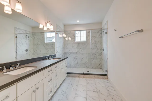 a spacious bathroom with a granite countertop sink mirror and shower