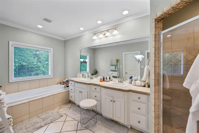 a spacious bathroom with a double vanity sink a mirror and a bathtub