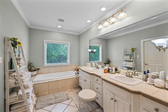 a spacious bathroom with a double vanity sink a mirror and a bathtub