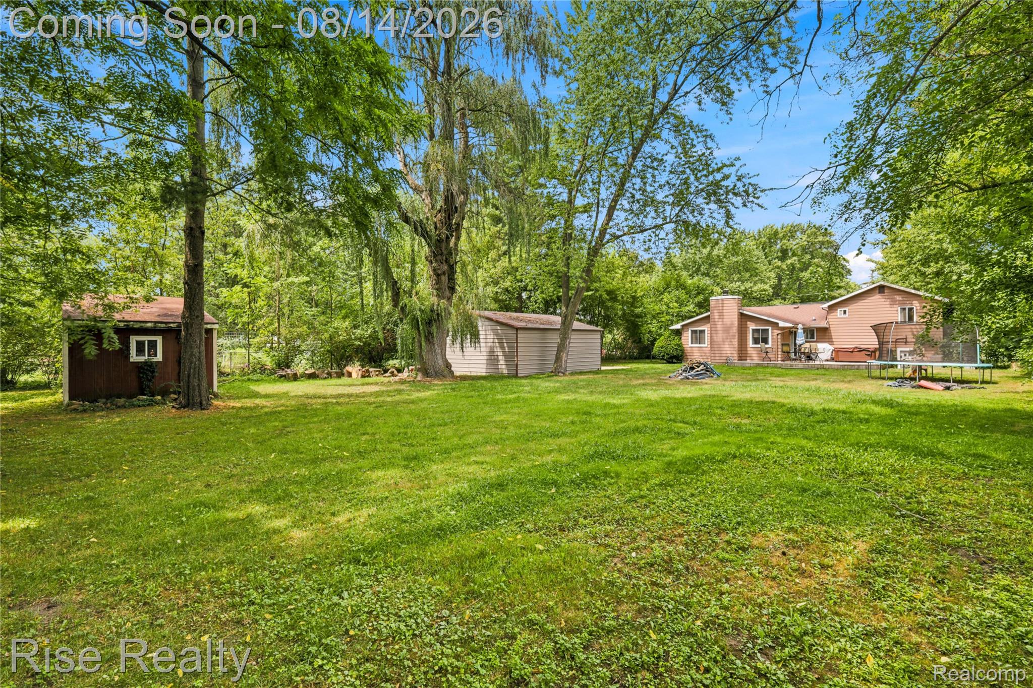 10215 West Frances Road Flushing, MI 48433 - Photo 28 of 31 Expansive backyard featuring a large lawn, mature trees, and two outbuildings
