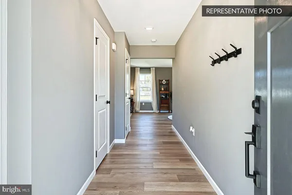 a view of a hallway with wooden floor and stairs