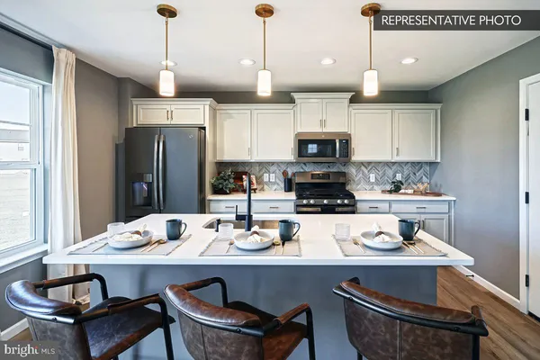 a kitchen with kitchen island a sink counter and chairs
