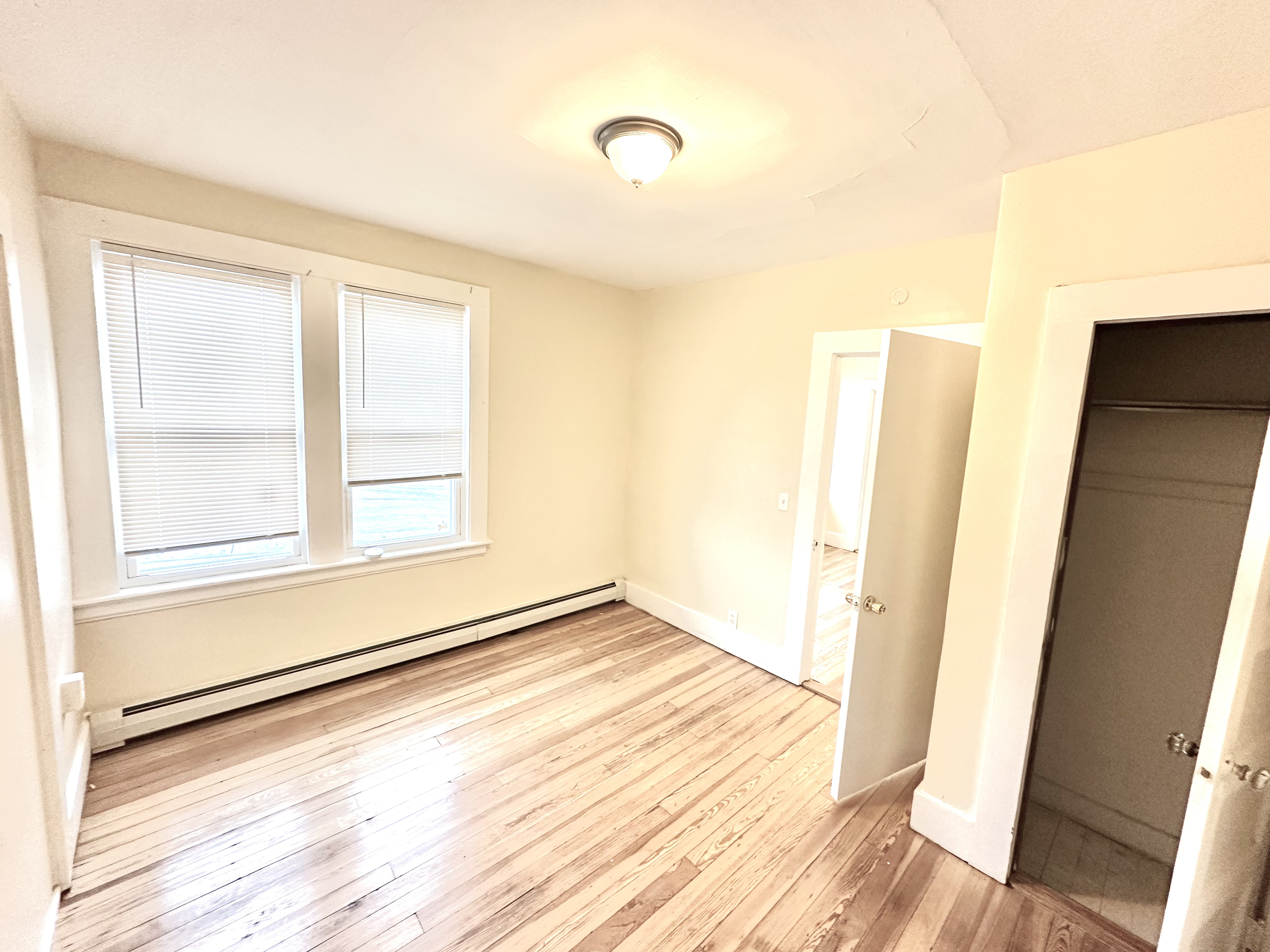 1019 West Main Street, Unit 3L Waterbury, CT 06708 - Photo 11 of 29 a view of an empty room with wooden floor and a window