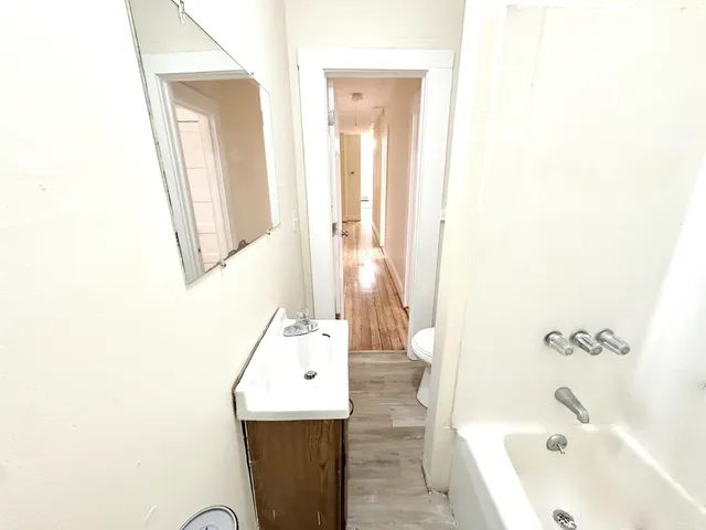 a bathroom with a tub sink and mirror