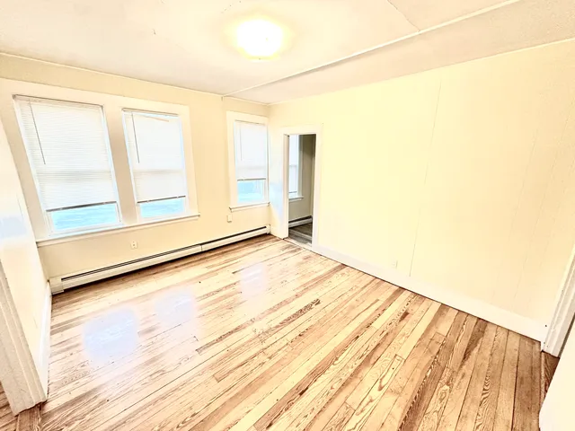 a view of a room with wooden floor and white walls