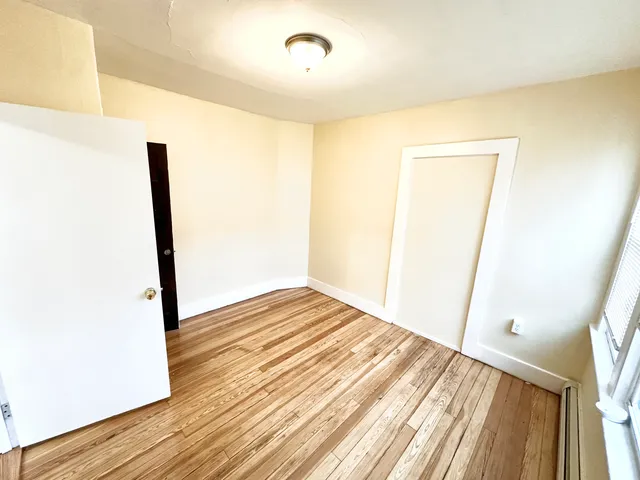 a view of a room with wooden floor and a window