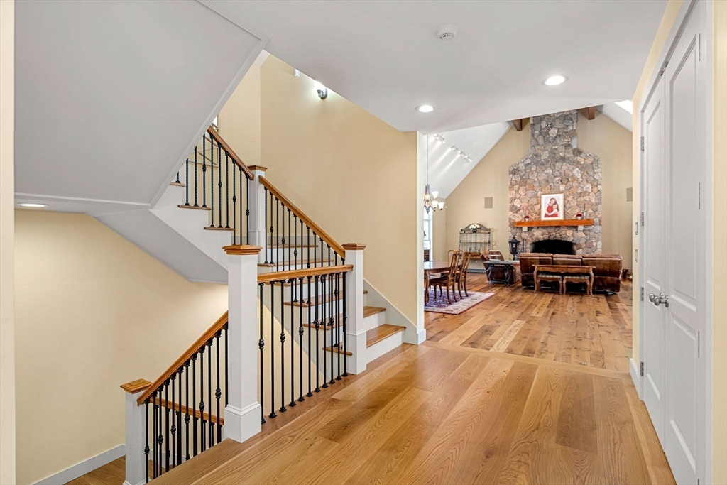 72 Dale Lane Groton, MA 01450 - Photo 14 of 42 a view of a hallway with wooden floor staircase and kitchen view