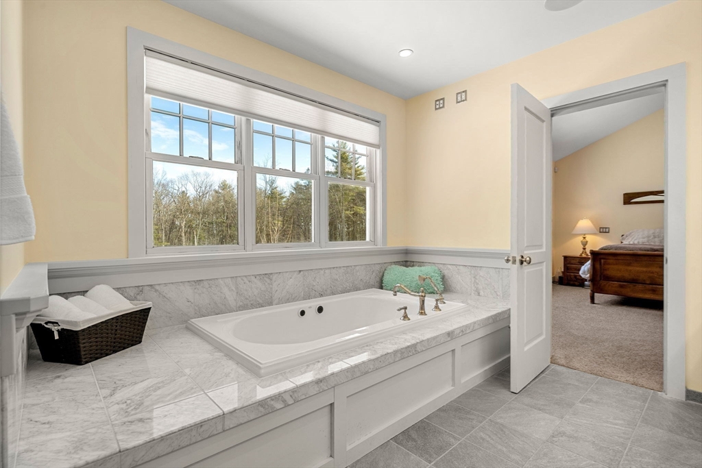 72 Dale Lane Groton, MA 01450 - Photo 22 of 42 a bathroom with a tub double vanity and a window