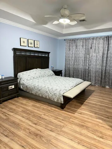 a bedroom with a bed and wooden floor