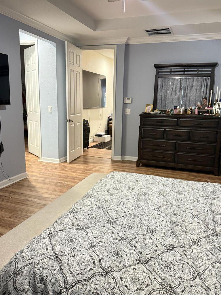 2891 Cedar Dunes Drive Port St. Lucie, FL 34953 - Photo 13 of 25 a bedroom with a bed and wooden floor