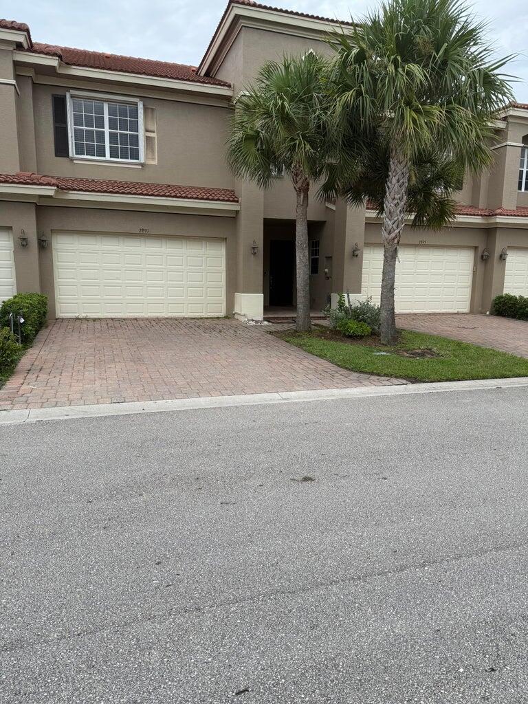 2891 Cedar Dunes Drive Port St. Lucie, FL 34953 - Photo 2 of 25 front view of house with a yard and palm trees