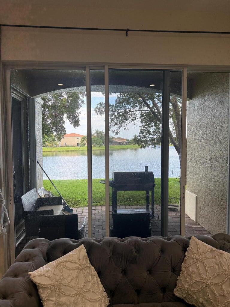 2891 Cedar Dunes Drive Port St. Lucie, FL 34953 - Photo 22 of 25 a living room with furniture and a floor to ceiling window