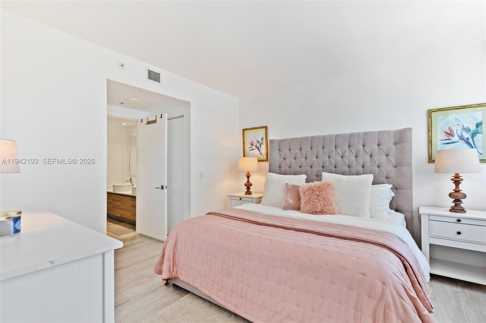 121 Northeast 34th Street, Unit 1008 Miami, FL 33137 - Photo 12 of 52 a bedroom with a bed and a lamp on the dresser