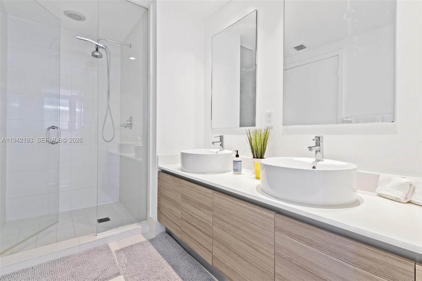 121 Northeast 34th Street, Unit 1008 Miami, FL 33137 - Photo 14 of 52 a bathroom with double sink and a shower
