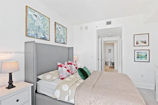 a bedroom with a bed and a lamp on dresser