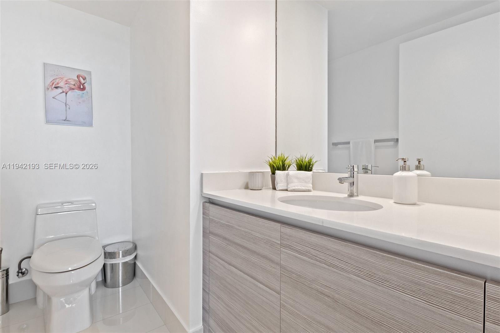 121 Northeast 34th Street, Unit 1008 Miami, FL 33137 - Photo 23 of 52 a bathroom with a toilet a sink and a mirror