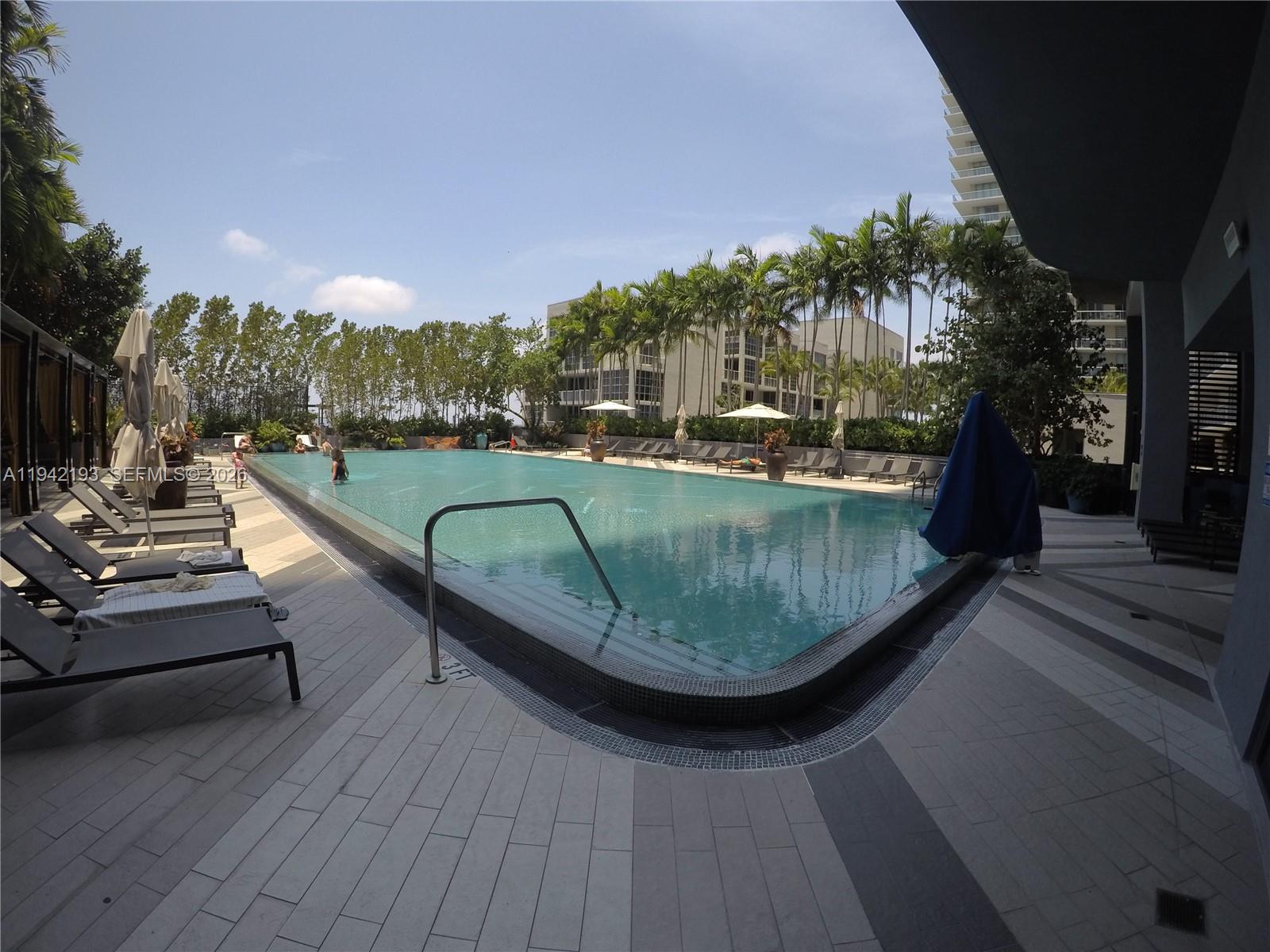 121 Northeast 34th Street, Unit 1008 Miami, FL 33137 - Photo 31 of 52 a view of a swimming pool with outdoor seating and plants
