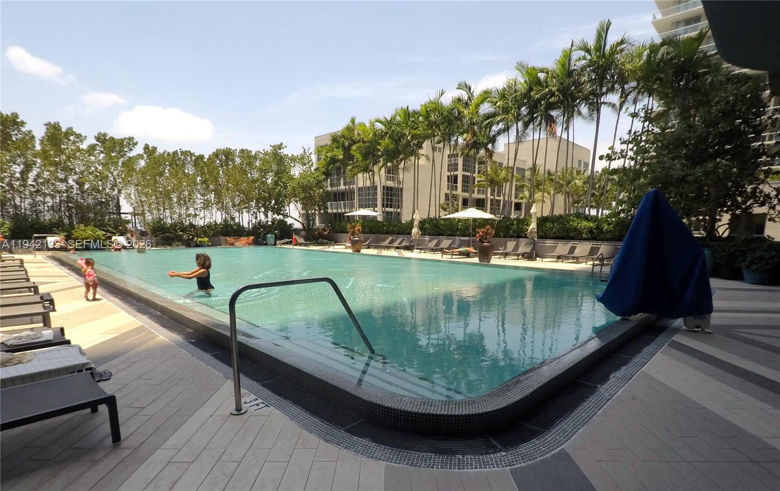 121 Northeast 34th Street, Unit 1008 Miami, FL 33137 - Photo 32 of 52 a swimming pool with outdoor seating and stairs