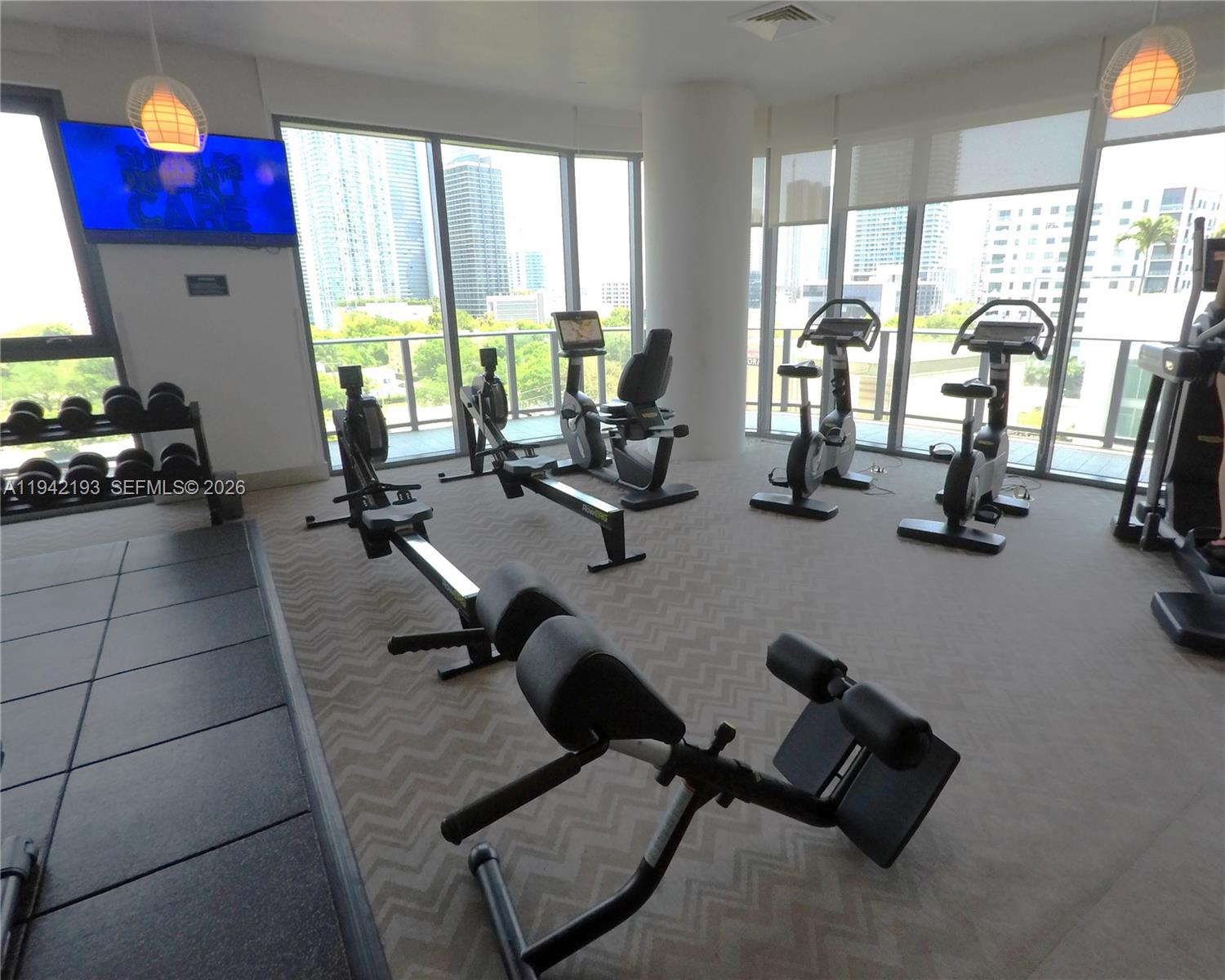 121 Northeast 34th Street, Unit 1008 Miami, FL 33137 - Photo 43 of 52 a room with gym equipment and a large window