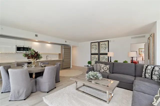 a living room with furniture a chandelier and a dining table