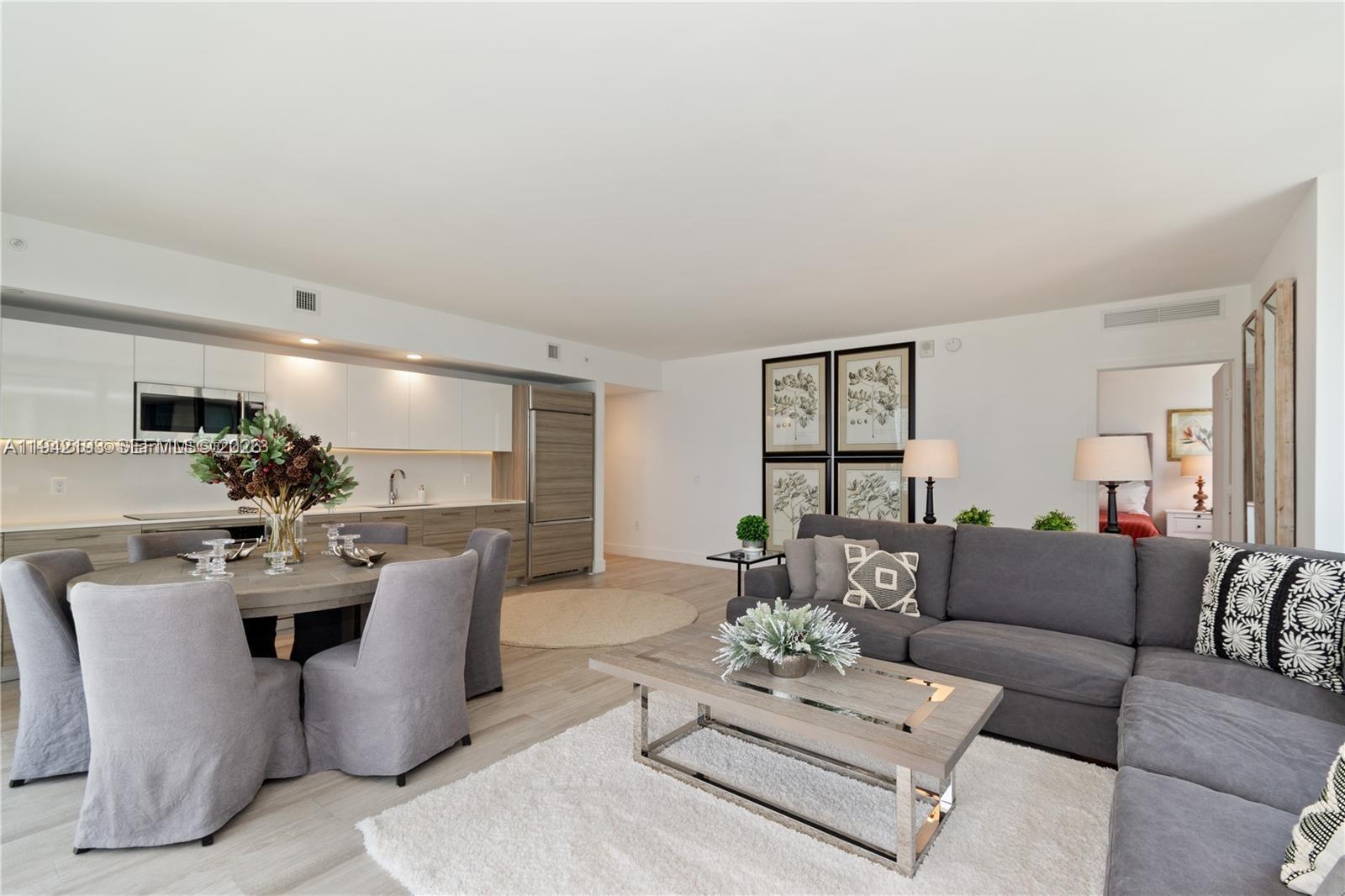 121 Northeast 34th Street, Unit 1008 Miami, FL 33137 - Photo 6 of 52 a living room with furniture a chandelier and a dining table