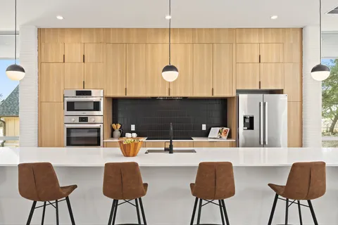 a kitchen with stainless steel appliances a table and chairs in it