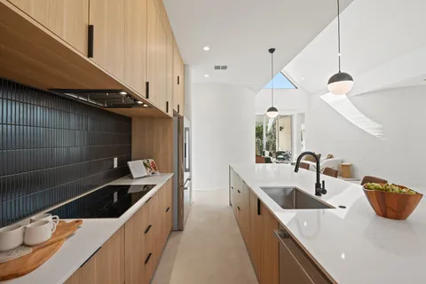 a kitchen with stainless steel appliances a sink a stove and a wooden floor