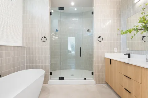 a bathroom with a tub shower sink and mirror